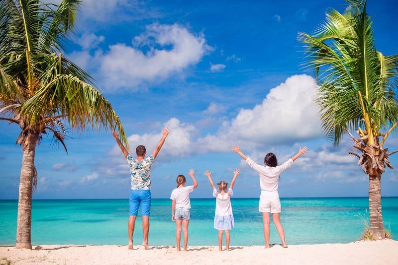 Família em praia paradisíaca de águas azuis